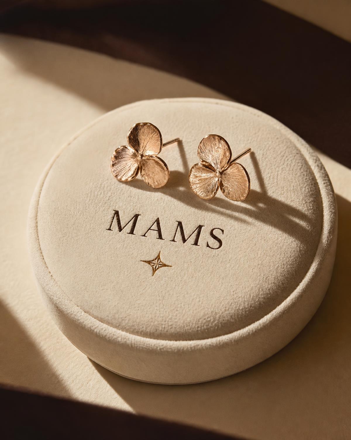 MAMS Petal Studs in hand-chased 18K rose gold, shown small against ivory paper